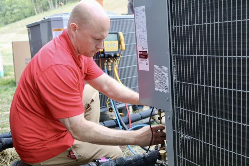 A technician assessing an outdoor HVAC unit