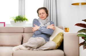 Woman shivering on the couch.