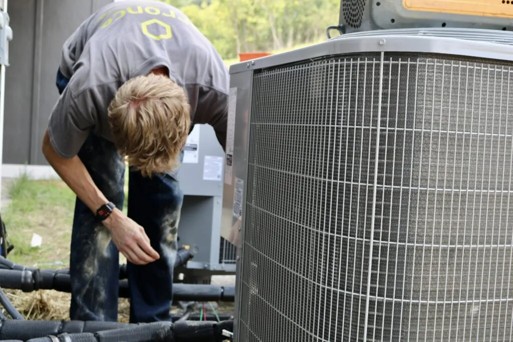 An Arronco technician servicing an outdoor HVAC unit