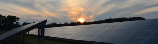 Ground-mounted solar panels at dusk.