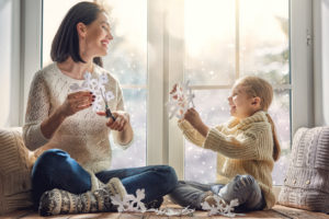 Mother and daughter staying warm while making holiday decorations